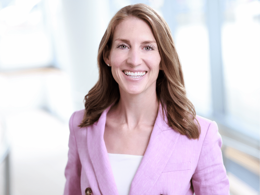 Professional woman wearing a pink blazer posing for corporate headshots in NYC