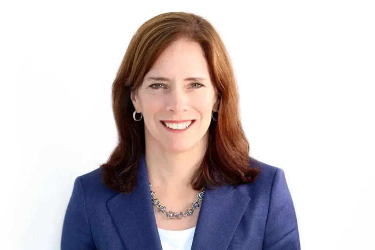 Professional woman in a blue blazer smiling for her corporate headshots NYC against a clean white background.